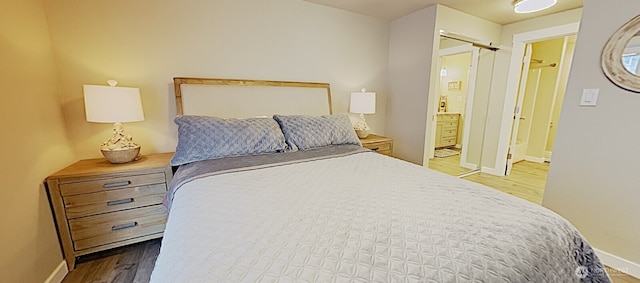 3060 NE Wheeler St, Poulsbo, WA 98370 - bedroom featuring wood finished floors, baseboards, and ensuite bathroom