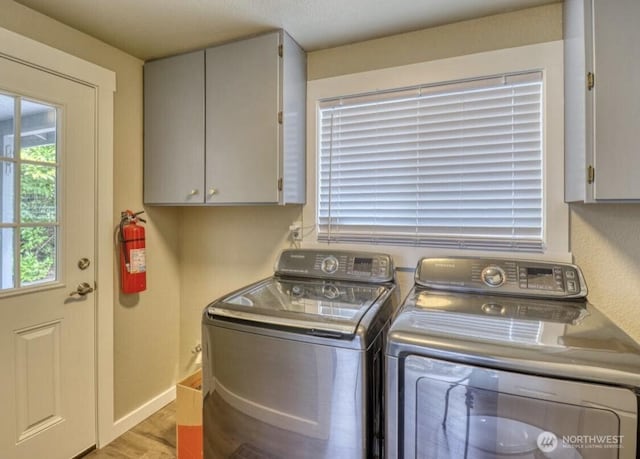 3060 NE Wheeler St, Poulsbo, WA 98370 - laundry room with cabinet space, washing machine and clothes dryer, light wood finished floors, and baseboards