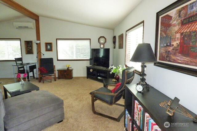 716 Dennis St SE Unit 48, Tumwater, WA 98501 - living area with lofted ceiling, an AC wall unit, carpet, and healthy amount of natural light