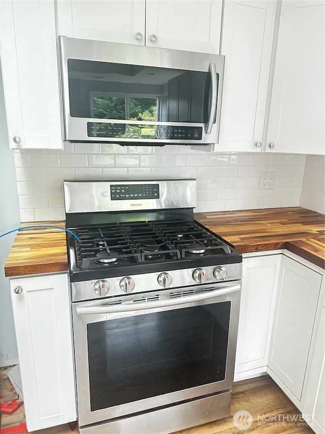 620 Hull Ave, Port Orchard, WA 98366 - kitchen with stainless steel appliances, butcher block countertops, white cabinetry, and backsplash