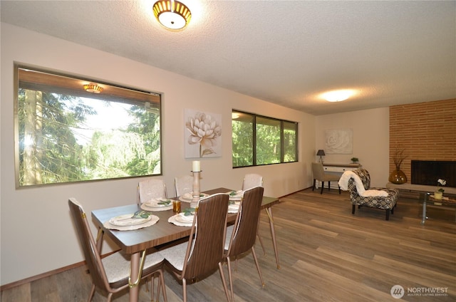 18215 108th Ave NE, Bothell, WA 98011 - dining space featuring healthy amount of natural light, wood finished floors, a textured ceiling, and a brick fireplace