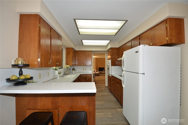 18215 108th Ave NE, Bothell, WA 98011 - kitchen with white appliances, a peninsula, brown cabinetry, and light wood finished floors