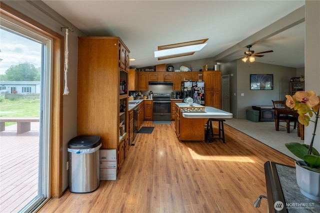 1822 W Devanny Ln, Port Angeles, WA 98363 - kitchen with electric stove, black fridge with ice dispenser, brown cabinetry, lofted ceiling, and light wood finished floors