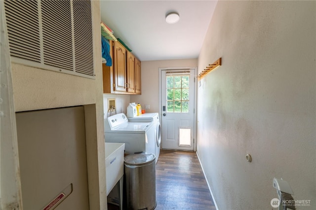 1822 W Devanny Ln, Port Angeles, WA 98363 - laundry room with washer and clothes dryer, cabinet space, dark wood finished floors, baseboards, and a textured wall