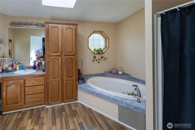 1822 W Devanny Ln, Port Angeles, WA 98363 - bathroom featuring a bath, vanity, wood finished floors, a skylight, and a shower with curtain