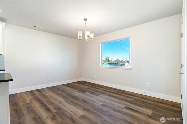 4214 W Sandy Ct, Moses Lake, WA 98837 - unfurnished dining area featuring a chandelier, baseboards, and dark wood-style flooring