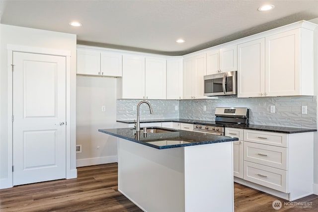 4214 W Sandy Ct, Moses Lake, WA 98837 - kitchen with appliances with stainless steel finishes, a sink, white cabinets, a center island with sink, and dark stone countertops