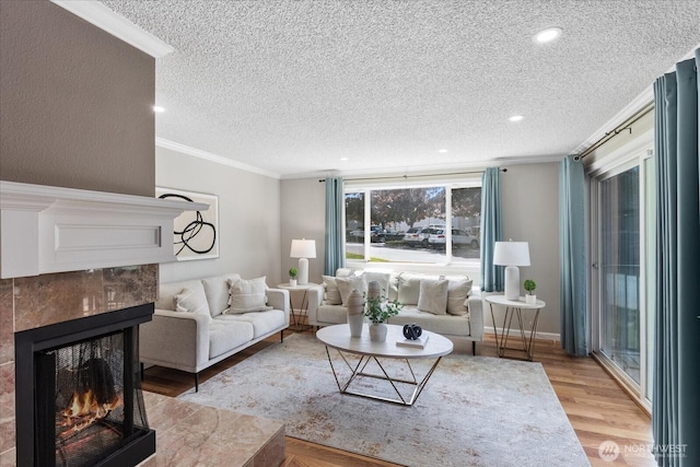 13009 E Gibson Rd Unit Q130, Everett, WA 98204 - living area featuring a textured ceiling, a tile fireplace, wood finished floors, crown molding, and recessed lighting