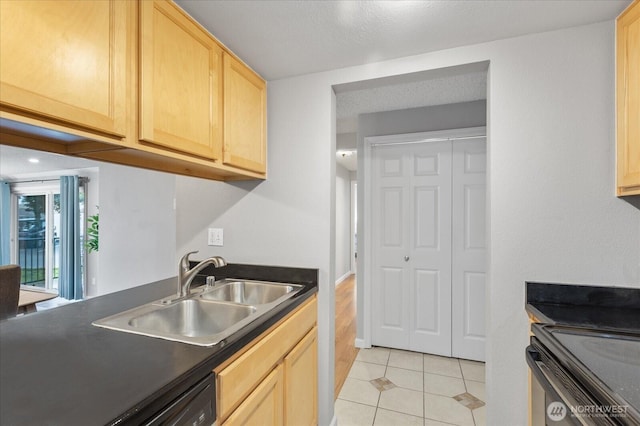 13009 E Gibson Rd Unit Q130, Everett, WA 98204 - kitchen featuring light brown cabinetry, a sink, dark countertops, light tile patterned flooring, and black range with electric stovetop