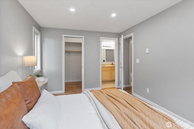 13009 E Gibson Rd Unit Q130, Everett, WA 98204 - bedroom featuring recessed lighting, baseboards, wood finished floors, ensuite bathroom, and a spacious closet