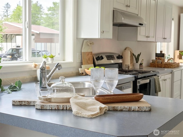 7127 Ortelius Dr, Ilwaco, WA 98624 - kitchen featuring under cabinet range hood, stainless steel gas range oven, white cabinets, and light countertops