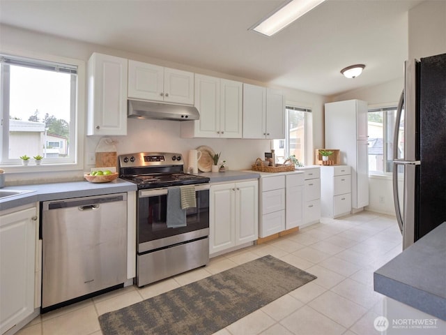 7127 Ortelius Dr, Ilwaco, WA 98624 - kitchen with stainless steel appliances, under cabinet range hood, white cabinetry, and light tile patterned floors
