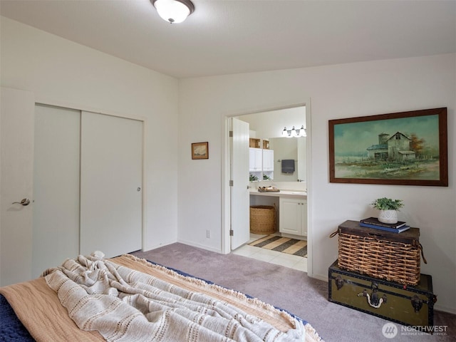 7127 Ortelius Dr, Ilwaco, WA 98624 - bedroom featuring light carpet, a closet, ensuite bathroom, and baseboards