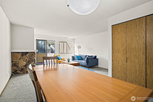 12044 96th Ave NE Unit 221, Kirkland, WA 98034 - carpeted dining room featuring a textured ceiling and a fireplace