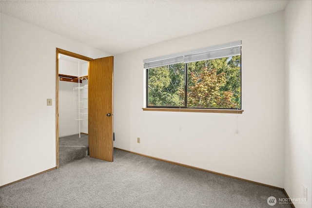 12044 96th Ave NE Unit 221, Kirkland, WA 98034 - unfurnished bedroom featuring carpet flooring, a spacious closet, and baseboards