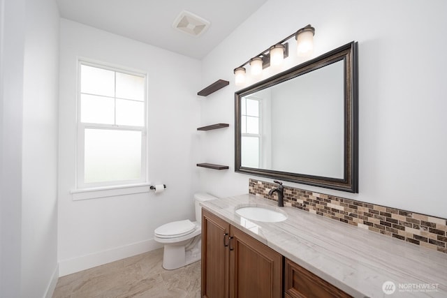 7328 Stonecrest Rd NE, Moses Lake, WA 98837 - bathroom with baseboards, vanity, toilet, and decorative backsplash