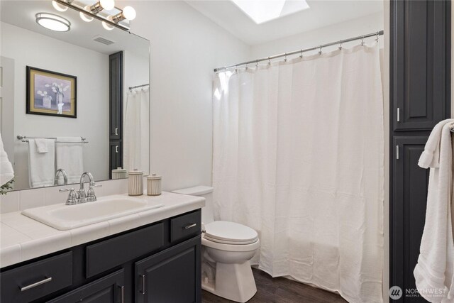 1361 E Old Ranch Rd, Allyn, WA 98524 - full bath with toilet, vanity, wood finished floors, and a skylight