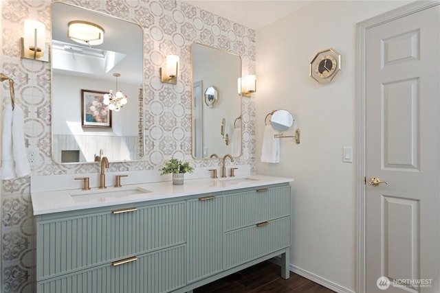 1361 E Old Ranch Rd, Allyn, WA 98524 - bathroom featuring double vanity, wood finished floors, wallpapered walls, and baseboards