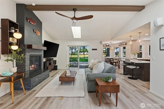 1361 E Old Ranch Rd, Allyn, WA 98524 - living area with ceiling fan, light wood-type flooring, a glass covered fireplace, and baseboards