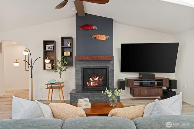 1361 E Old Ranch Rd, Allyn, WA 98524 - living room featuring arched walkways, ceiling fan, wood finished floors, a fireplace, and baseboards