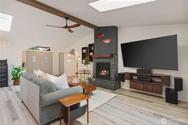 1361 E Old Ranch Rd, Allyn, WA 98524 - living room with a skylight, wood finished floors, a fireplace, arched walkways, and a ceiling fan