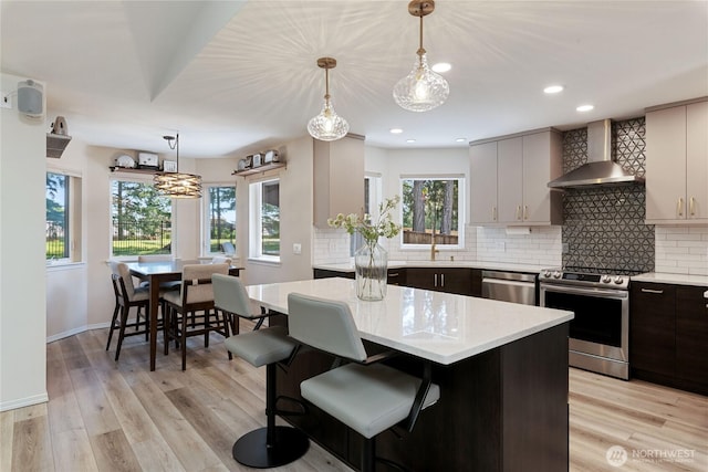 1361 E Old Ranch Rd, Allyn, WA 98524 - kitchen featuring stainless steel appliances, wall chimney range hood, decorative backsplash, recessed lighting, and light wood finished floors