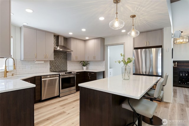 1361 E Old Ranch Rd, Allyn, WA 98524 - kitchen featuring wall chimney exhaust hood, stainless steel appliances, a sink, light wood-style flooring, and gray cabinetry