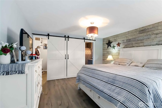 2337 W Castleman St, Longview, WA 98632 - bedroom featuring a barn door, wood walls, dark wood-style floors, and an accent wall