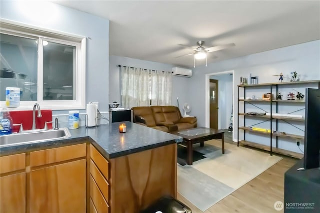 2337 W Castleman St, Longview, WA 98632 - kitchen with a sink, a wall unit AC, a ceiling fan, light wood-style flooring, and brown cabinetry