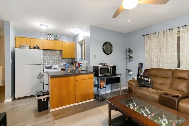 2337 W Castleman St, Longview, WA 98632 - kitchen with white appliances, decorative backsplash, ceiling fan, dark countertops, and a sink