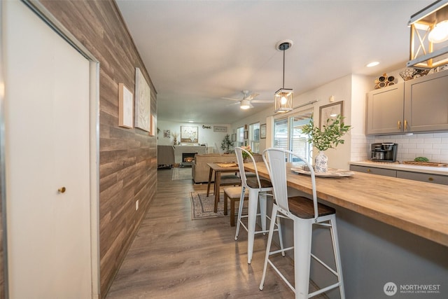 3217 289th St S, Roy, WA 98580 - kitchen featuring butcher block countertops, wood finished floors, a kitchen breakfast bar, a ceiling fan, and open floor plan
