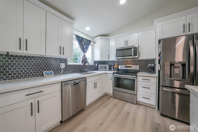 33137 35th Ave SW, Federal Way, WA 98023 - kitchen with appliances with stainless steel finishes, a sink, light countertops, white cabinets, and lofted ceiling