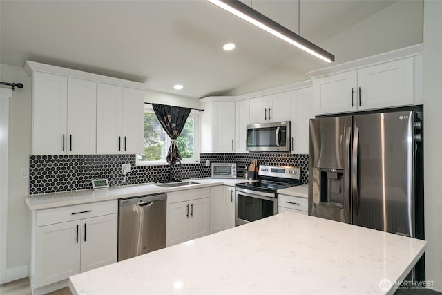 33137 35th Ave SW, Federal Way, WA 98023 - kitchen with stainless steel appliances, a sink, lofted ceiling, tasteful backsplash, and white cabinetry