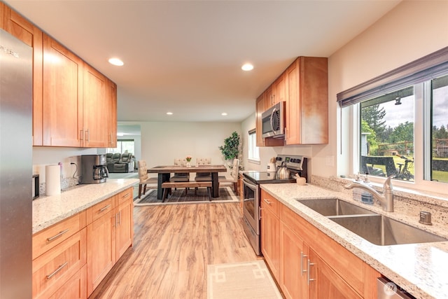 4718 252nd St NE, Arlington, WA 98223 - kitchen with appliances with stainless steel finishes, a sink, light wood-style floors, recessed lighting, and light stone counters