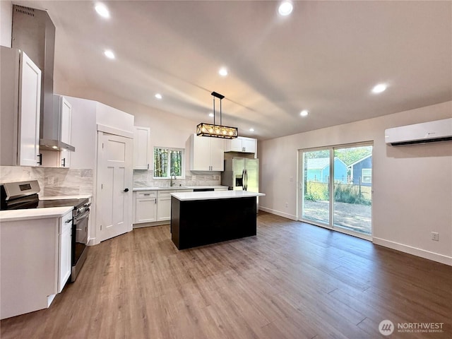 127 Olympic View Ave NE, Ocean Shores, WA 98569 - kitchen featuring appliances with stainless steel finishes, a wall mounted AC, a center island, tasteful backsplash, and light countertops