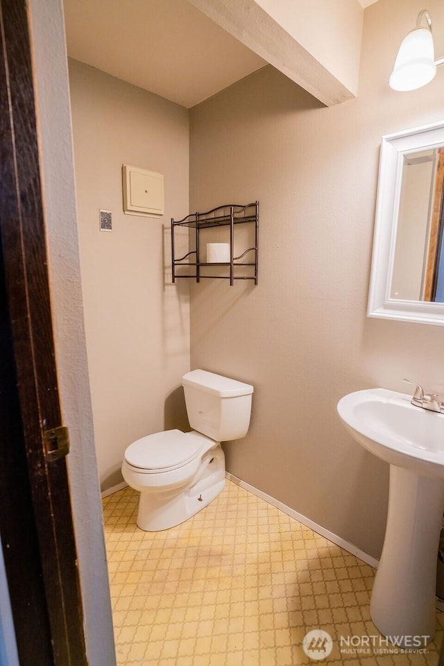 306 Belmont Ave, Moses Lake, WA 98837 - half bathroom featuring toilet, tile patterned floors, baseboards, and a sink