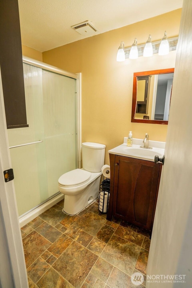 306 Belmont Ave, Moses Lake, WA 98837 - bathroom with stone tile floors, vanity, a shower stall, and toilet