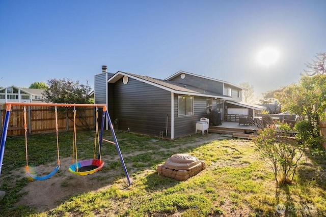 306 Belmont Ave, Moses Lake, WA 98837 - back of property featuring a playground, a wooden deck, a chimney, and a fire pit