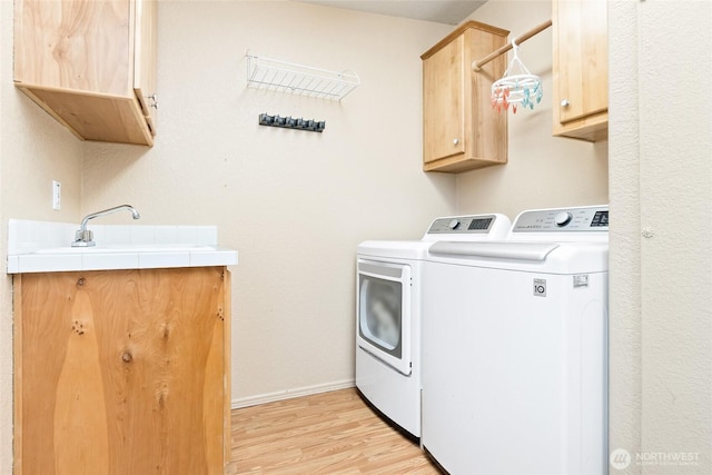 119 Oyler Way, Ethel, WA 98542 - washroom featuring cabinet space, washer and clothes dryer, light wood-style flooring, and baseboards