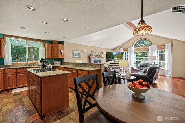 5990 6th Ave SE, Lacey, WA 98503 - kitchen featuring stainless steel gas cooktop, a kitchen island, open floor plan, brown cabinets, and recessed lighting