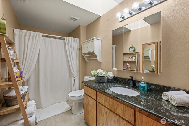 5990 6th Ave SE, Lacey, WA 98503 - bathroom featuring vanity, a textured wall, toilet, and tile patterned flooring