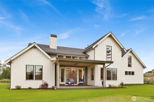 5712 Denali Ln, Bellingham, WA 98226 - back of house with a chimney, a lawn, a patio area, a shingled roof, and board and batten siding