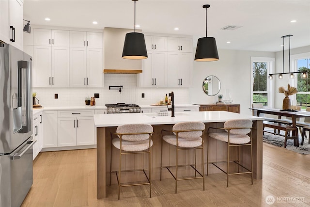 5712 Denali Ln, Bellingham, WA 98226 - kitchen with high end fridge, custom exhaust hood, light wood-type flooring, light countertops, and range