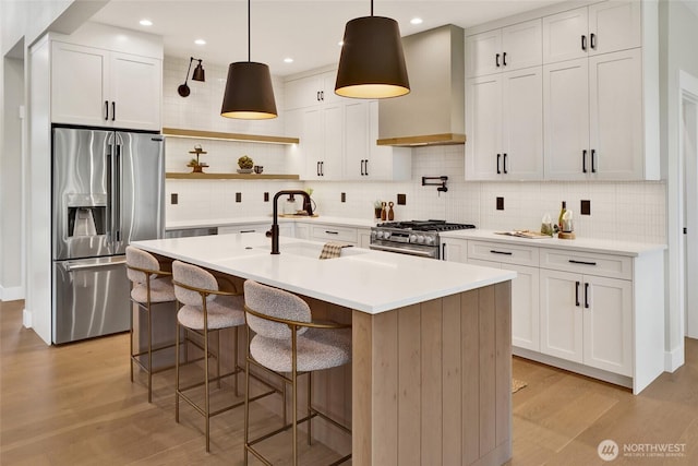 5712 Denali Ln, Bellingham, WA 98226 - kitchen with appliances with stainless steel finishes, wall chimney range hood, light wood-style flooring, backsplash, and open shelves