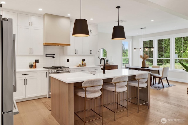 5712 Denali Ln, Bellingham, WA 98226 - kitchen with stainless steel appliances, custom range hood, light wood-type flooring, tasteful backsplash, and light countertops