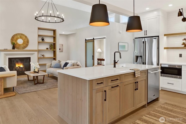 5712 Denali Ln, Bellingham, WA 98226 - kitchen with appliances with stainless steel finishes, open shelves, open floor plan, light countertops, and light wood-style flooring