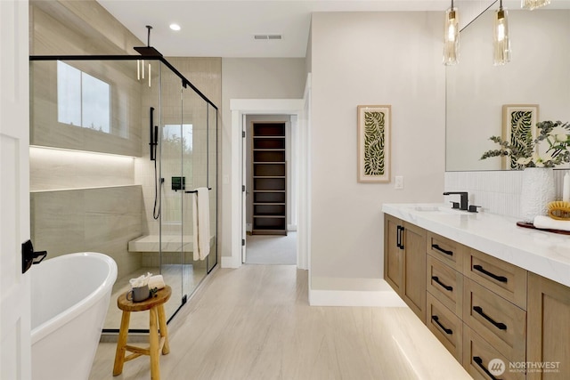 5712 Denali Ln, Bellingham, WA 98226 - bathroom featuring a stall shower, a freestanding bath, double vanity, recessed lighting, and a walk in closet