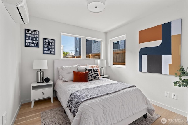 4519A Bagley Ave N, Seattle, WA 98103 - bedroom featuring an AC wall unit, multiple windows, and wood finished floors