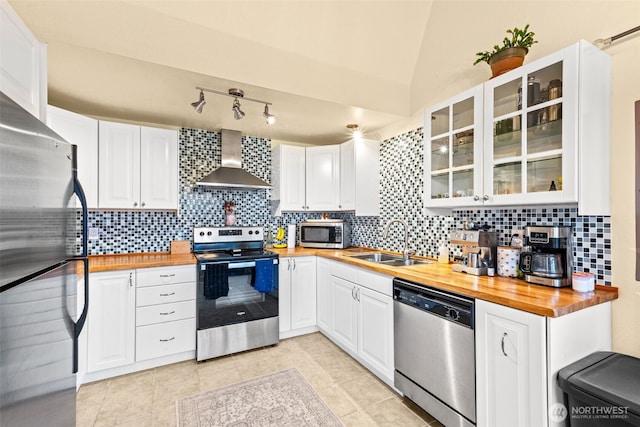 1291 Channel Ave SW, Ocean Shores, WA 98569 - kitchen featuring stainless steel appliances, wall chimney exhaust hood, butcher block countertops, a sink, and tasteful backsplash