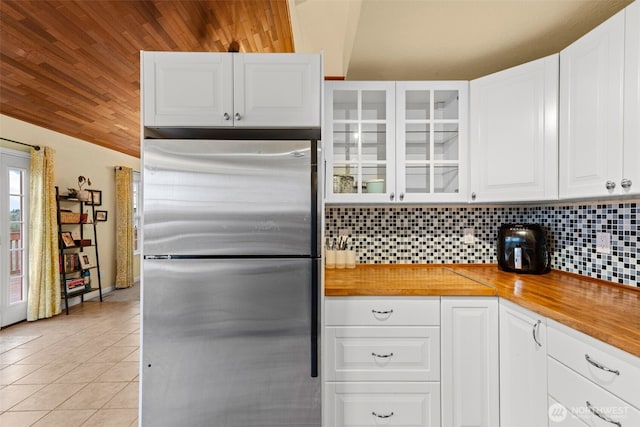 1291 Channel Ave SW, Ocean Shores, WA 98569 - kitchen with freestanding refrigerator, light tile patterned floors, tasteful backsplash, glass insert cabinets, and wood ceiling